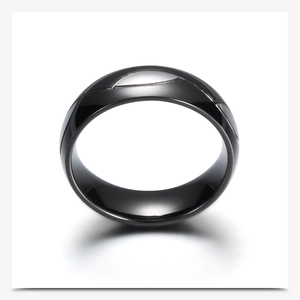 Primer plano del anillo negro de acero inoxidable pulido con líneas curvas grabadas