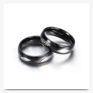 Detalle de anillos de pareja en acero inoxidable negro con circonitas y acabado pulido