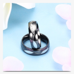 Detalle de anillos de pareja negros de acero inoxidable con circonitas y diseño de olas
