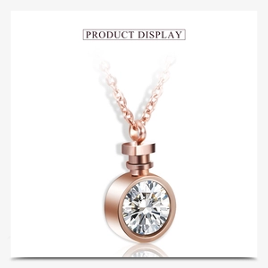 Macro detail of rose gold perfume bottle pendant necklace with sparkling crystal