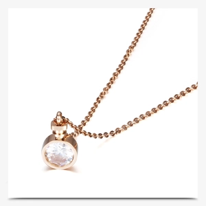 Macro shot of rose gold perfume bottle necklace with sparkling round diamond pendant
