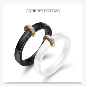 Detail von minimalistischen Keramikringen in Schwarz und Weiß mit Gold und 5 Zirkonia