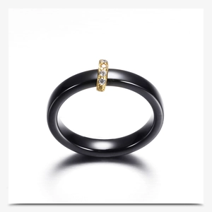 Makro-Detail des schwarzen Keramikrings mit vergoldetem Band und eingelegten Zirkonia
