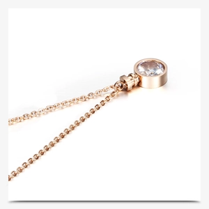 Detailed macro view of a rose gold perfume bottle pendant necklace with a sparkling zircon stone