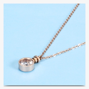 Close-up of rose gold cross chain necklace with a sparkling round zircon pendant