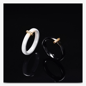 Details von minimalistischen Keramikringen in Schwarz und Weiß mit Gold-Zirkon-Inlay