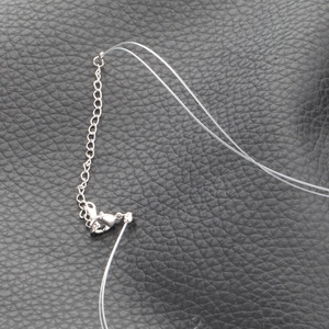 Close-up of adjustable silver lobster clasp and extension chain on clear nylon line