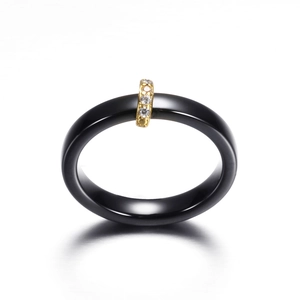 Minimalistischer schwarzer Keramikring mit Goldband und Mikro-Zirkon-Einlage auf Weiß