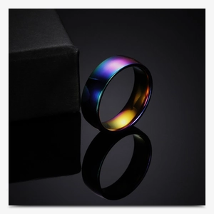 Detail of 6mm rainbow plated stainless steel ring with elegant reflection on black surface