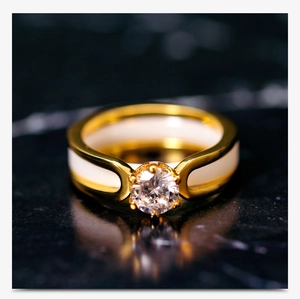 Macro detail of gold-tone ceramic ring featuring a six-prong set cubic zirconia centerpiece