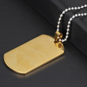 Close-up of polished gold rectangle dog tag pendant on a silver ball chain necklace
