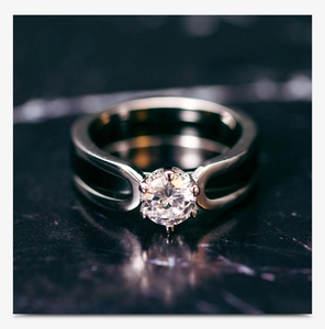 Macro shot of 6-prong round zircon setting on a sleek black ceramic ring band detail