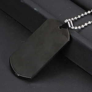 Close-up of polished black stainless steel dog tag necklace on black leather display
