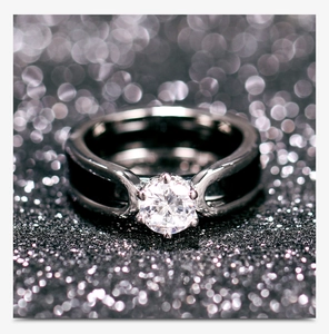 Close-up of a black ceramic ring featuring a large round cubic zirconia stone setting