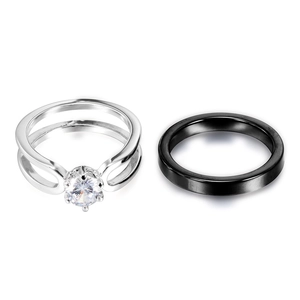Elegant set featuring a silver zircon engagement ring and a black ceramic band on white background