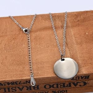 Detailed macro view of 25mm polished stainless steel pendant and lobster clasp chain
