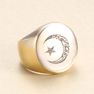 Detailed macro view of a polished gold signet ring featuring laser engraved star and moon