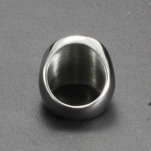Close-up of polished silver stainless steel ring on a dark textured leather background