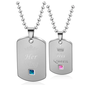 Detailed view of His Queen and Her King dog tag pendants with colored crystals and crown detail