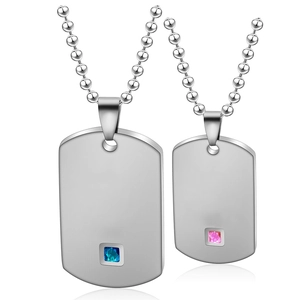 Detail of couple necklaces with dog tag pendants, blue and pink gems, and ball chains