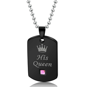 Detail of a black matte dog tag necklace featuring a crown, His Queen text and pink gem