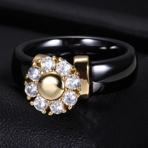 Macro shot of 6mm black ceramic ring featuring a golden flower inset with sparkling zircons