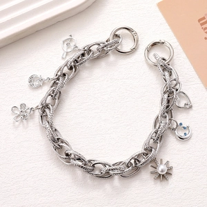 Macro shot of silver alloy charm chain featuring a pearl flower and blue zircon moon pendant