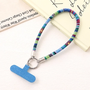 Detail view of a colorful braided ethnic-style phone wrist strap with a blue patch insert