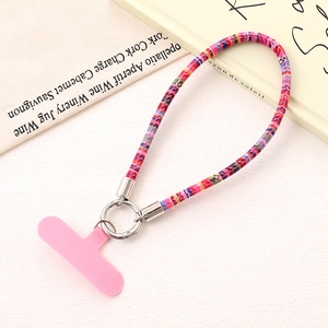 Detailed view of colorful woven wrist phone strap with silver ring clasp and pink tab