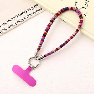 Detailed view of a rainbow braided phone strap with a silver ring and pink patch