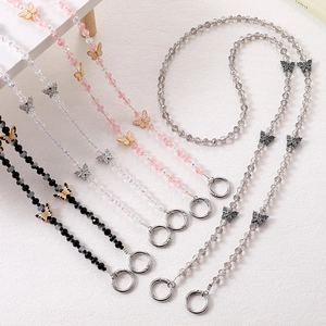 Detail of beaded bag straps with luxury metal butterfly charms and spring rings