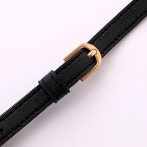 Close-up of adjustable black leather strap with gold buckle and precise stitching detail