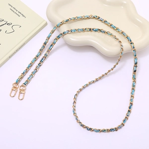 Detail of light gold chain strap woven with blue fabric for crossbody phone or bags