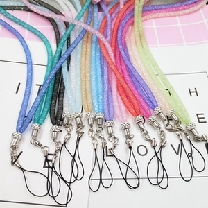 Detail of glittery colorful phone lanyards with rhinestone connectors and metal lobster clasps