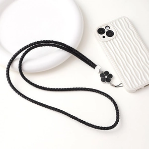 Close-up of black braided adjustable crossbody phone strap with black flower charm pendant