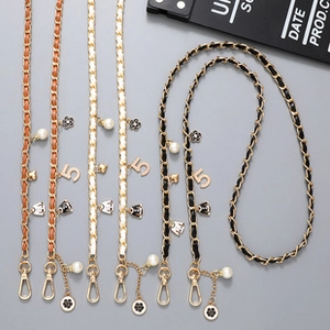 Detailed view of woven leather chain straps in black white and brown with charms