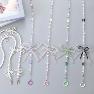 Detail of beaded phone strap with pearls, stars, and bows in various soft colors