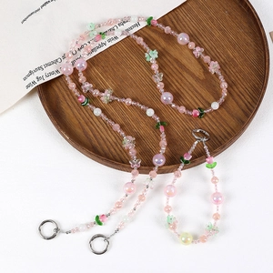 Detailed view of handmade pink beaded phone charms with tulip and butterfly accents