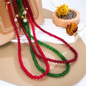 Chinese style beaded phone charm with red and green beads and a golden Fu pendant
