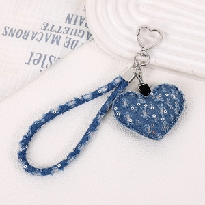 Détail du charme coeur en denim bleu avec paillettes argentées et fermoir cœur en métal