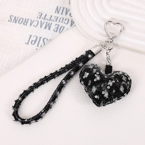 Détail d'un charm en jean noir en forme de cœur avec paillettes argentées et clip métal