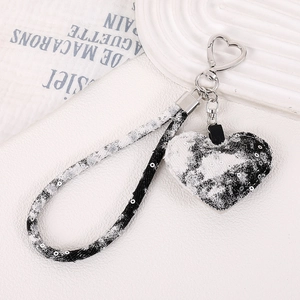 Détail du pendentif en marbre en forme de cœur avec boucle argentée et dragonne tressée