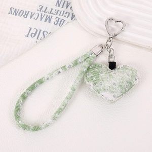 Détail du porte-clés coeur en tweed vert menthe avec sequins et fermoir coeur argenté