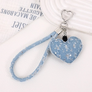 Détail d'un pendentif coeur en denim bleu clair avec paillettes et fermoir métallique