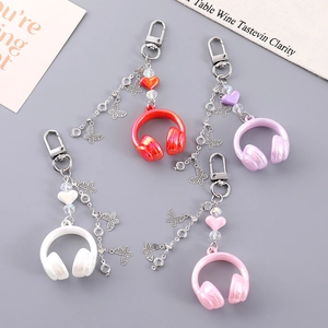 Flat lay of colorful 3D headphone bag charms with beaded chains and butterfly pendants