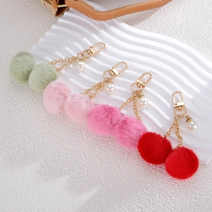 Furry cherry bag charms with plush pom-poms, pearls and gold keychains in four colors