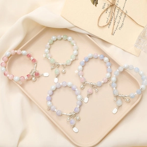 Detail of sweet floral acrylic beaded bracelets with silver star and bell pendants