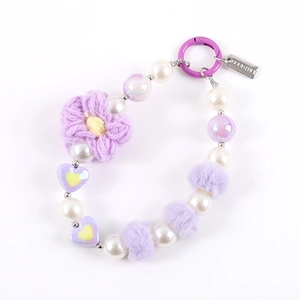 Purple handmade beaded phone charm with knitted flower and Good Luck metal tag