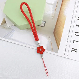 Detail of red braided leather phone strap with camellia pendant and sparkling rhinestone