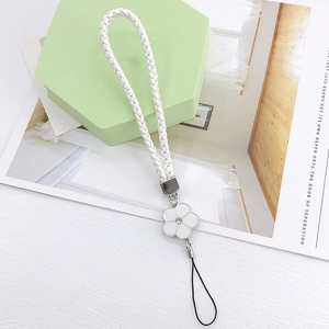 Close-up of white woven phone strap featuring a camellia charm with a sparkling crystal center